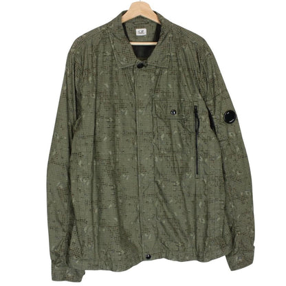CP Company khaki green overshirt jacket with digital camouflage pattern and lens detail.