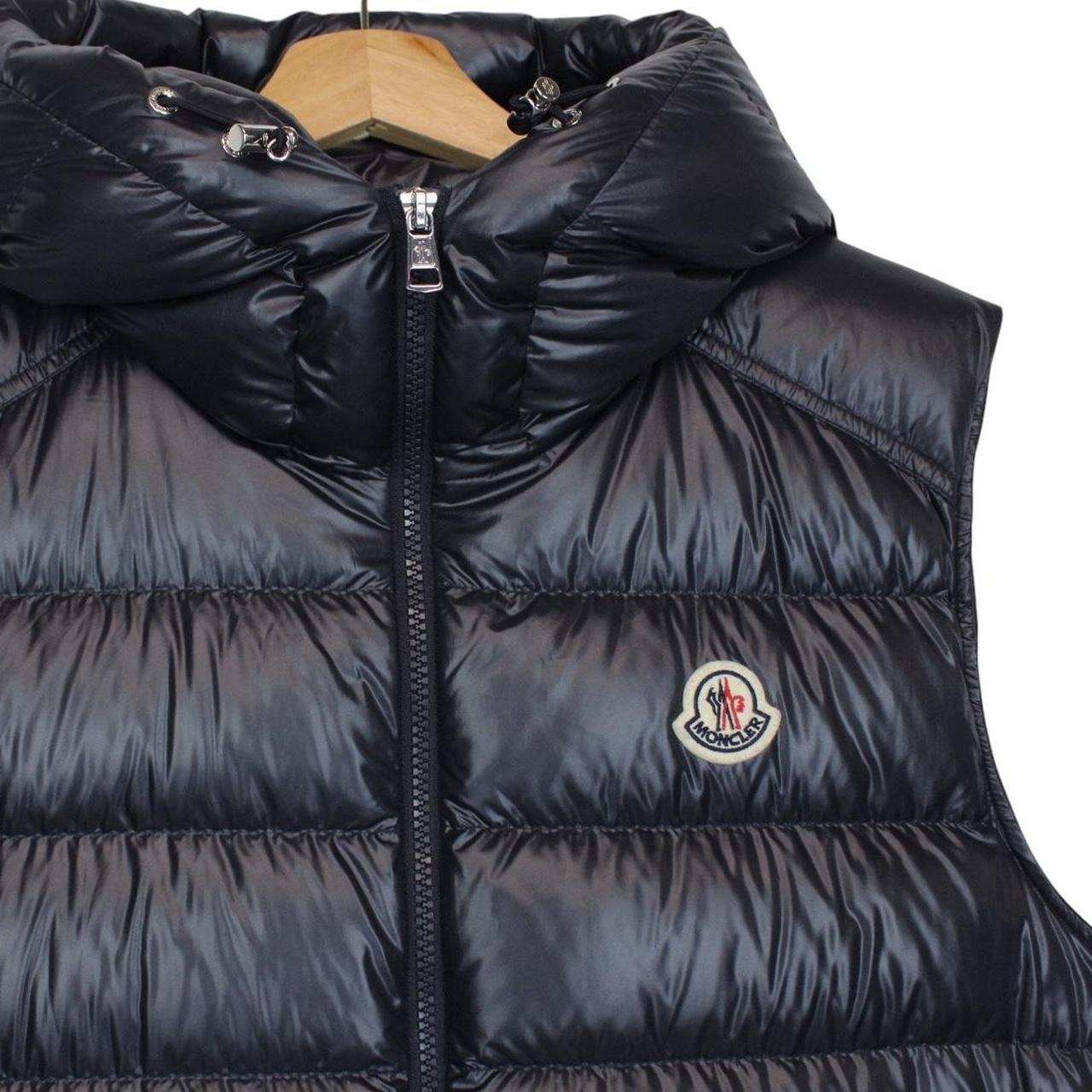 Moncler navy blue hooded nylon down gilet with logo and quilted texture.