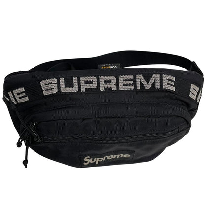Supreme black waist bag featuring logo print and durable material.