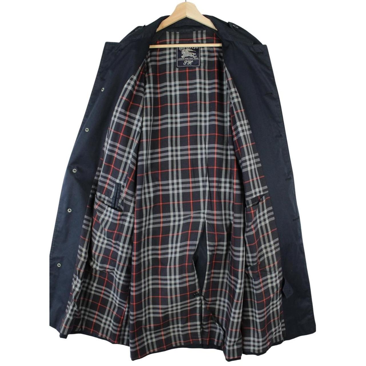 Burberry navy blue trench coat with belted waist and single breasted design.