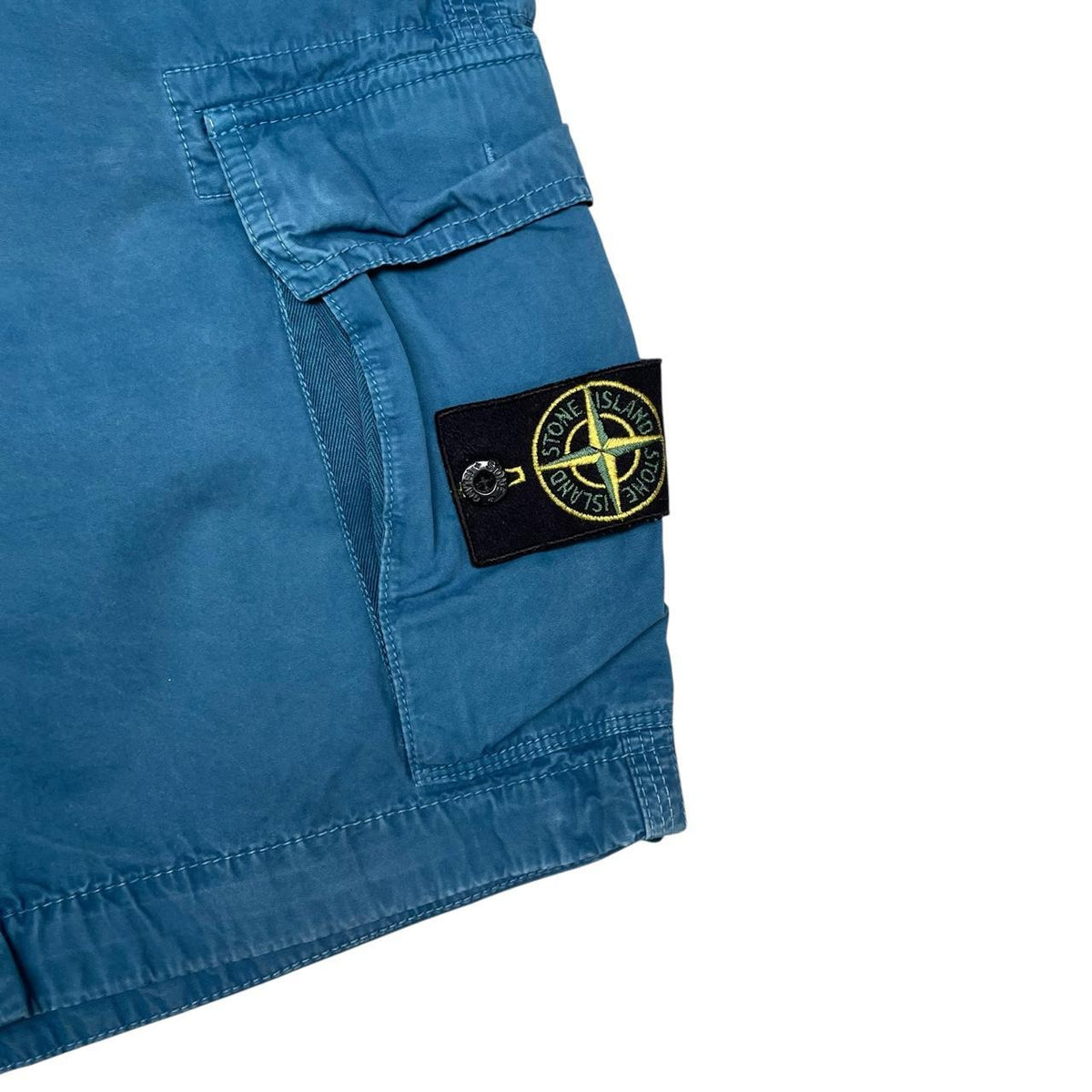 Stone Island teal blue cargo shorts with logo patch and cotton material.