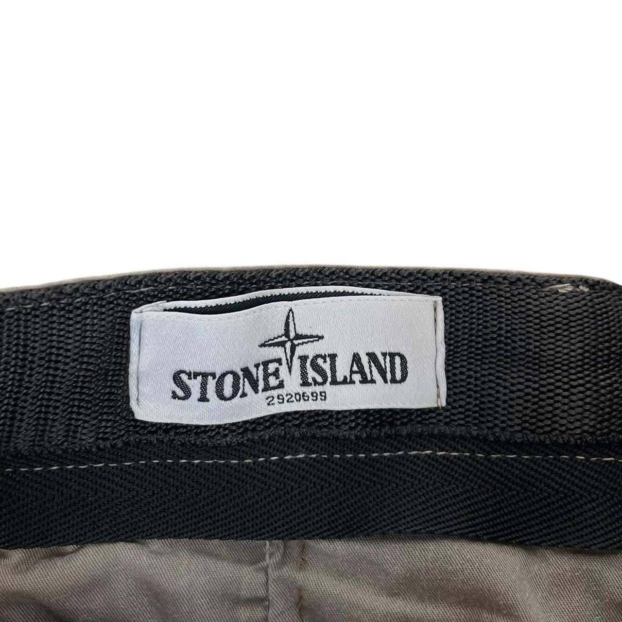Stone Island beige slim fit cotton trousers with logo patch and visible wear marks.