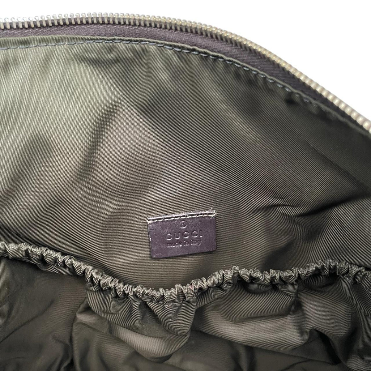 Gucci brown diaper changing bag with Supreme GG monogram and leather shoulder strap.