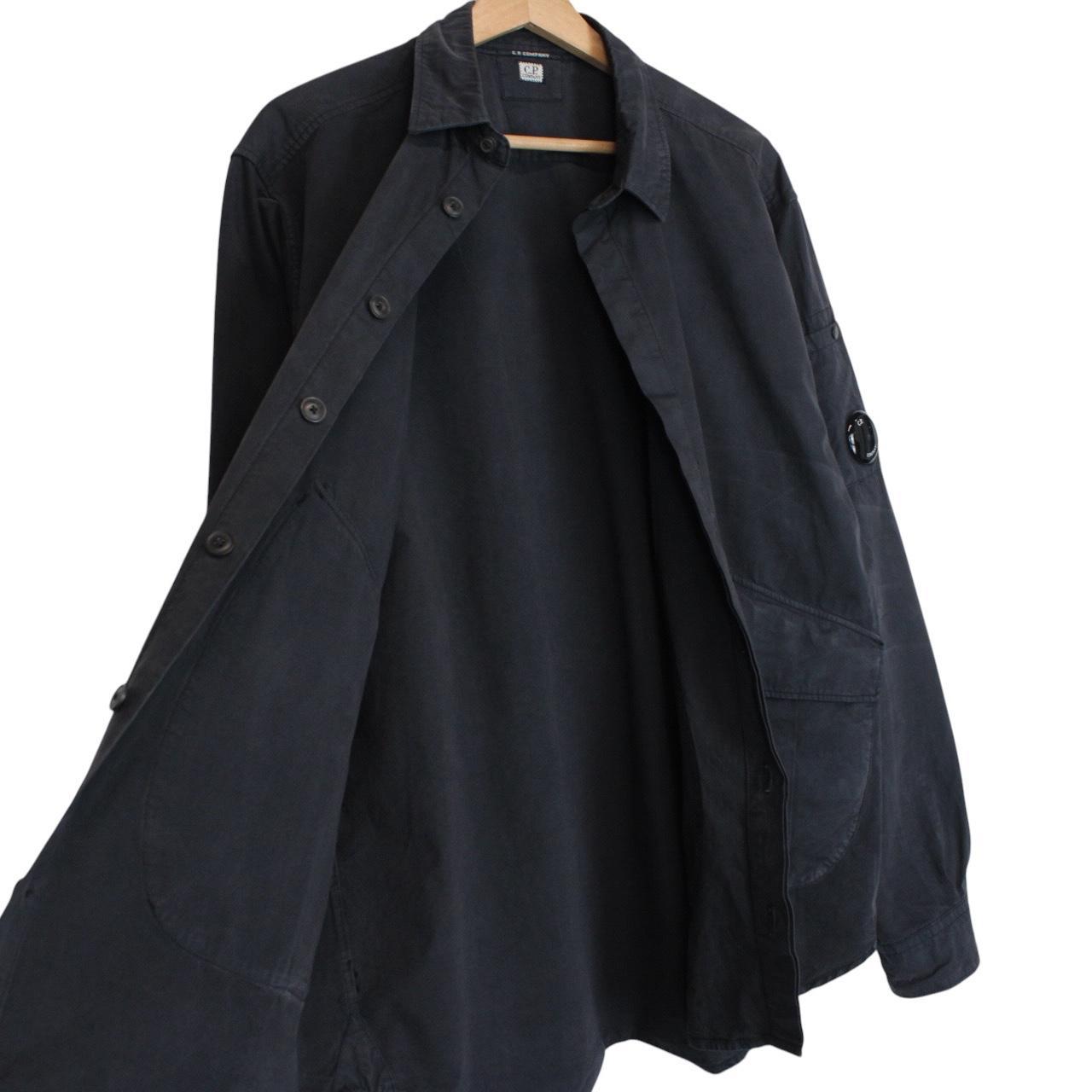 CP Company navy blue overshirt jacket with diamond pattern and lens detail.