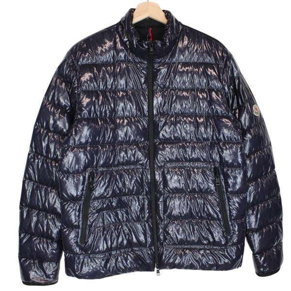 Moncler navy blue full zip down jacket with logo patch and quilted material.