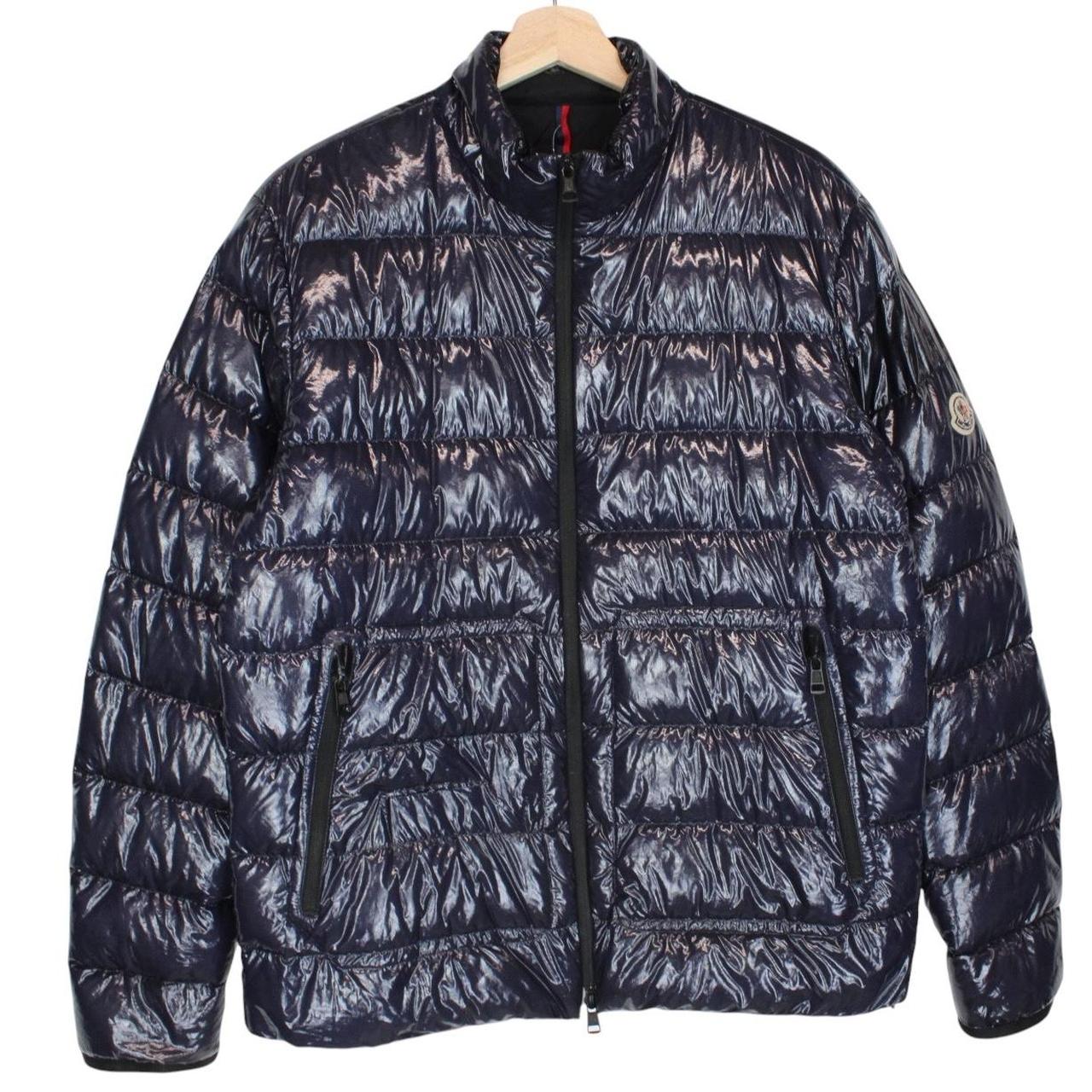Moncler navy blue full zip down jacket with logo patch and quilted material.