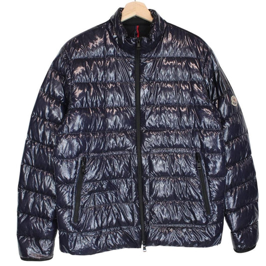 Moncler navy blue full zip down jacket with logo patch and quilted material.
