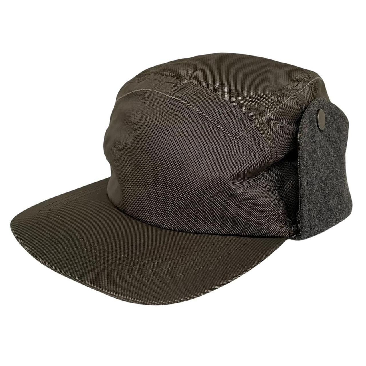 Paul Smith khaki green nylon ear-flap cap with logo detail and adjustable straps.