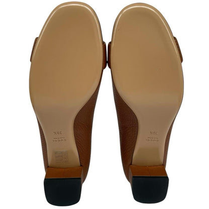 Gucci brown high heels with pebbled leather and interlocking G buckle detail.