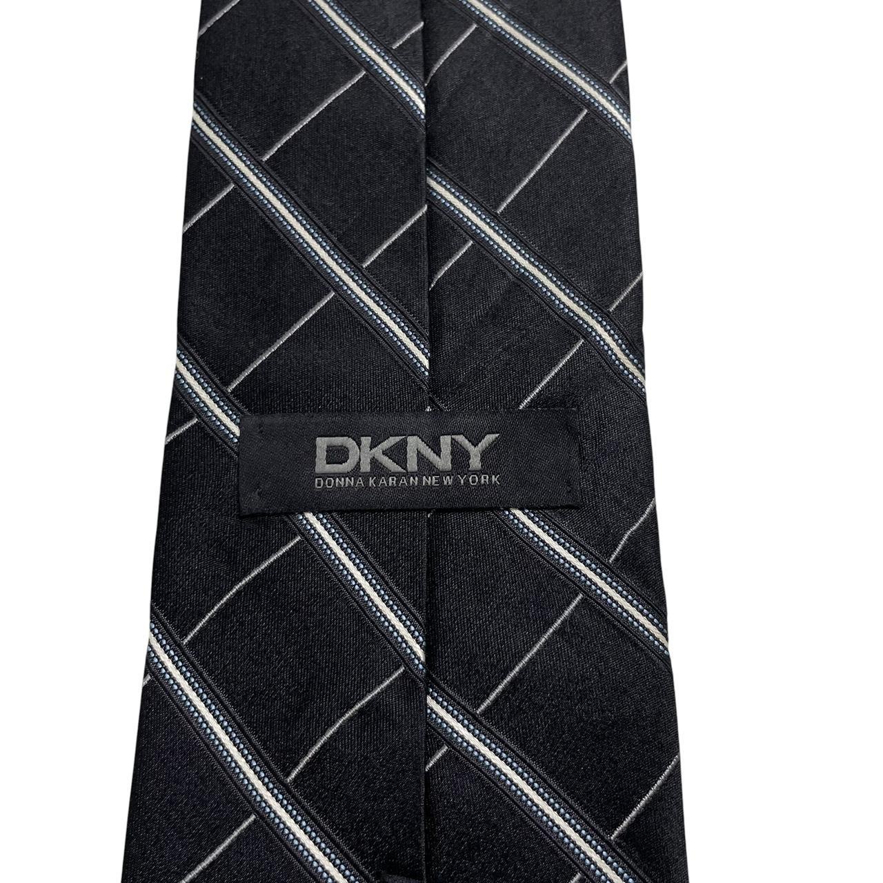 DKNY black silk tie with vintage striped pattern and logo detail.