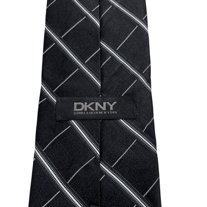 DKNY black silk tie with vintage striped pattern and logo detail.