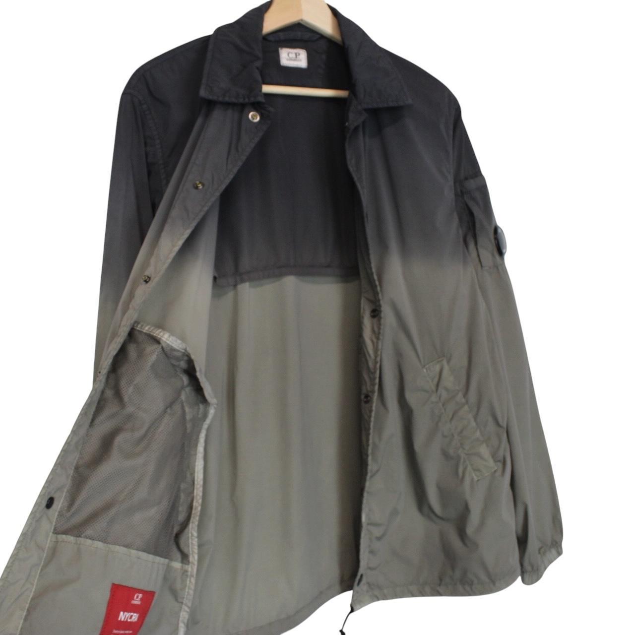 CP Company khaki green and grey jacket with shibori pattern and lens detail.