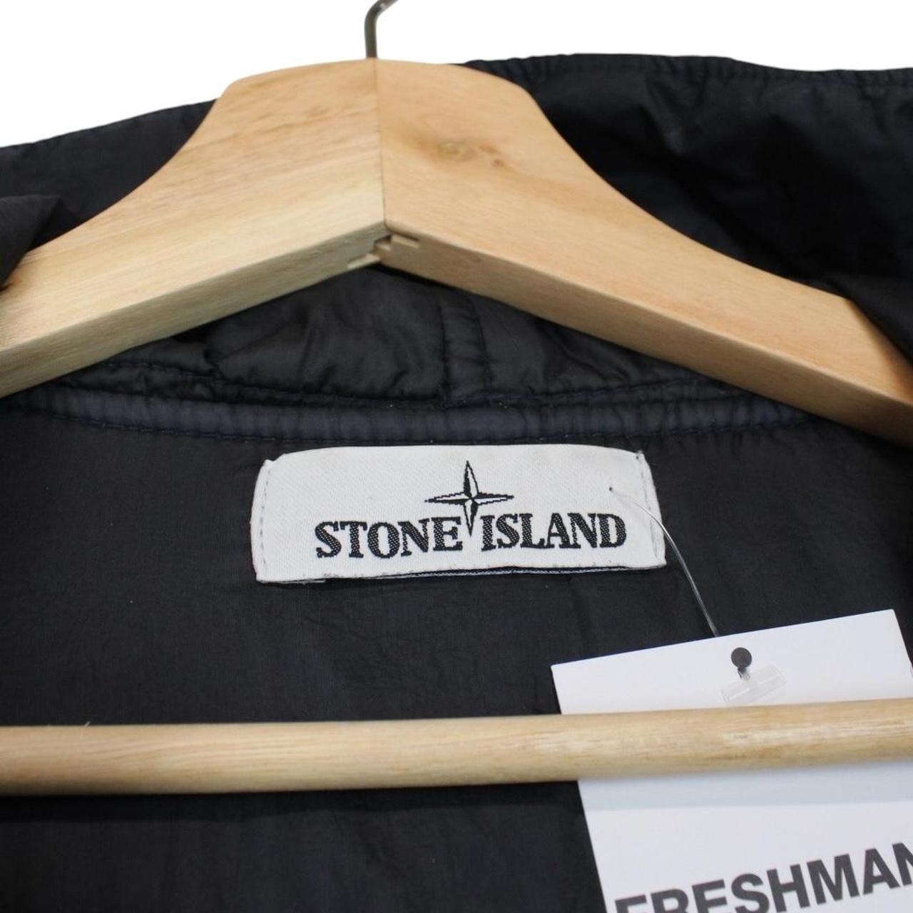 Stone Island black jacket with crinkle texture and logo patch on sleeve.