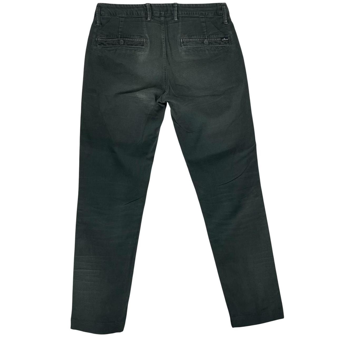 Stone Island green slim fit cotton trousers with logo patch and faded details.