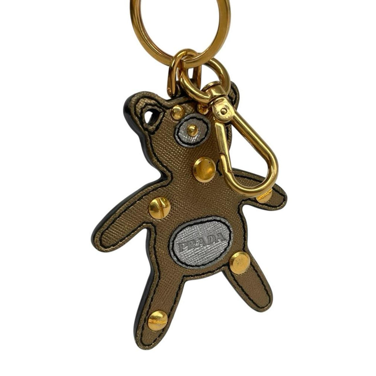 Prada brown and gold teddy bear bag charm in Saffiano leather with logo detail.