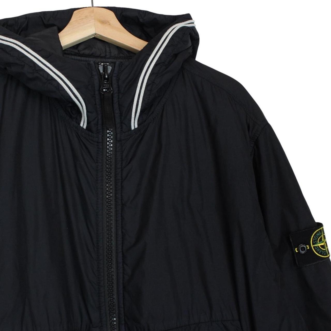 Stone Island black jacket with crinkle texture and logo patch on sleeve.