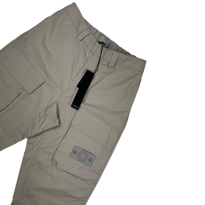 Stone Island beige cargo trousers with logo patch and multiple pockets.