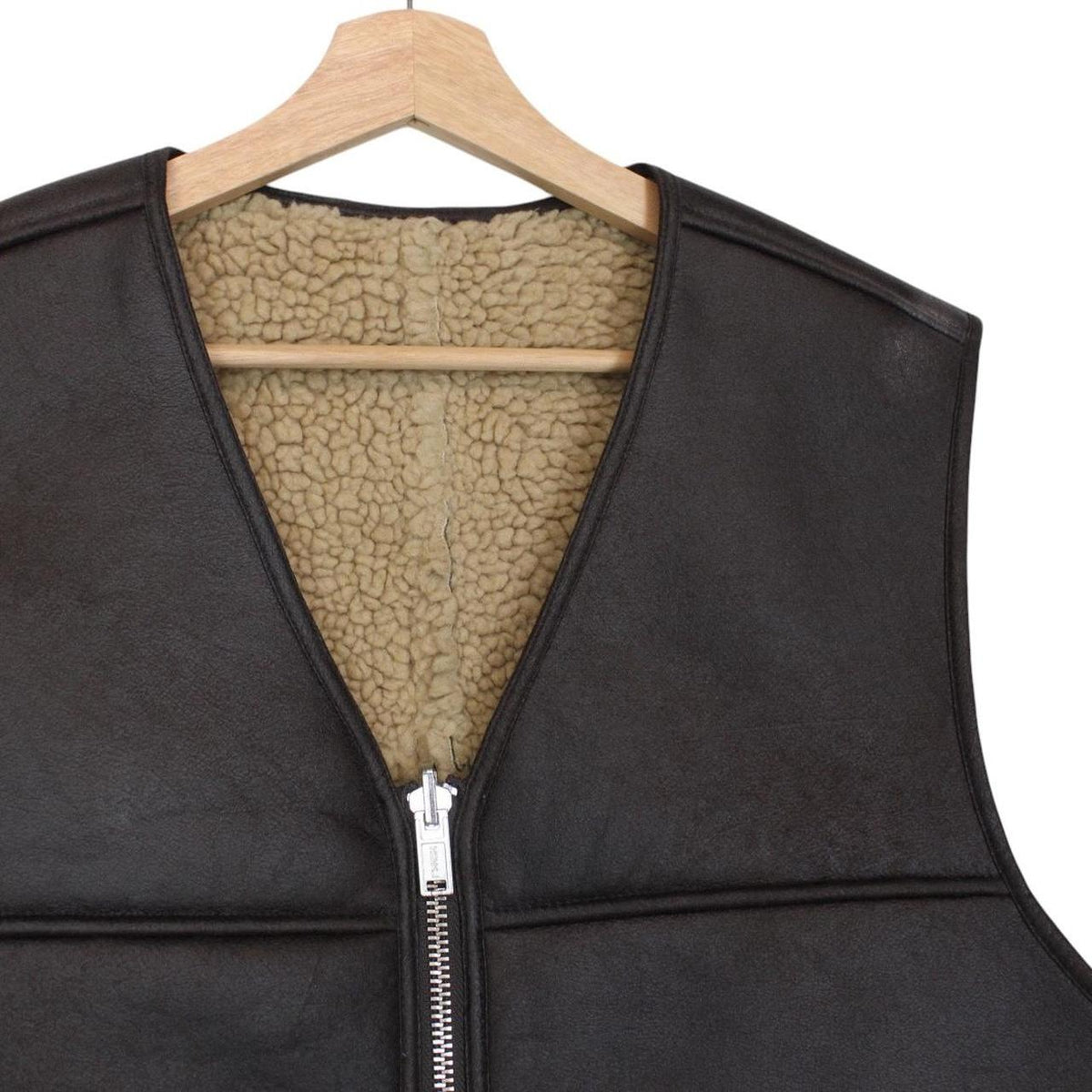 Supreme brown reversible faux shearling work vest with logo patch and textured fabric.