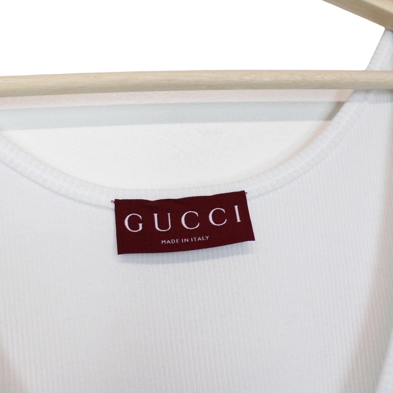 Gucci white tank top featuring bold logo print on soft cotton material.