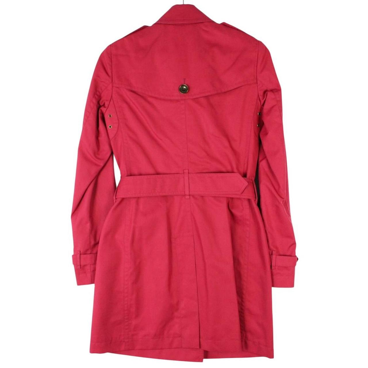 Burberry pink double breasted belted trench coat with classic check lining and logo buttons.