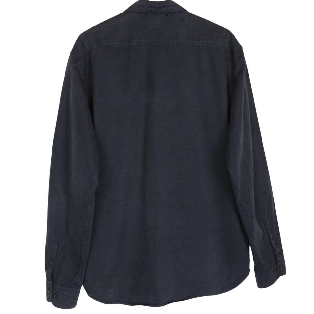 CP Company navy blue overshirt jacket with diamond pattern and lens detail.