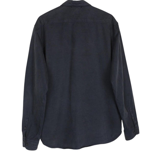 CP Company navy blue overshirt jacket with diamond pattern and lens detail.