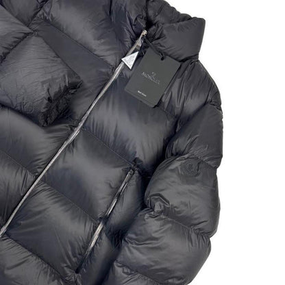 Moncler black nylon down puffer jacket with logo patch and quilted design.