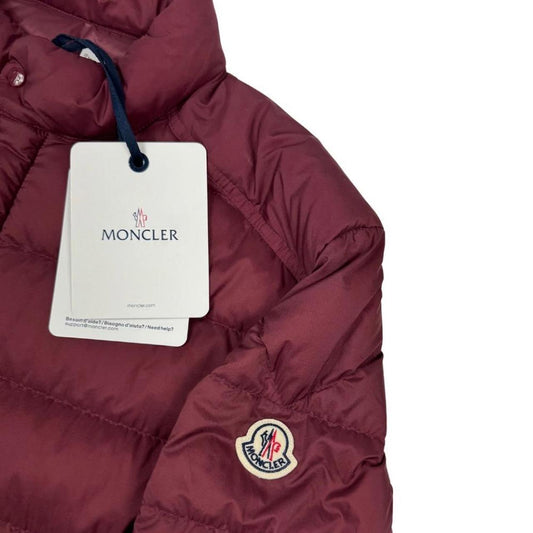 Moncler burgundy quilted down jacket with logo patch and shell material.