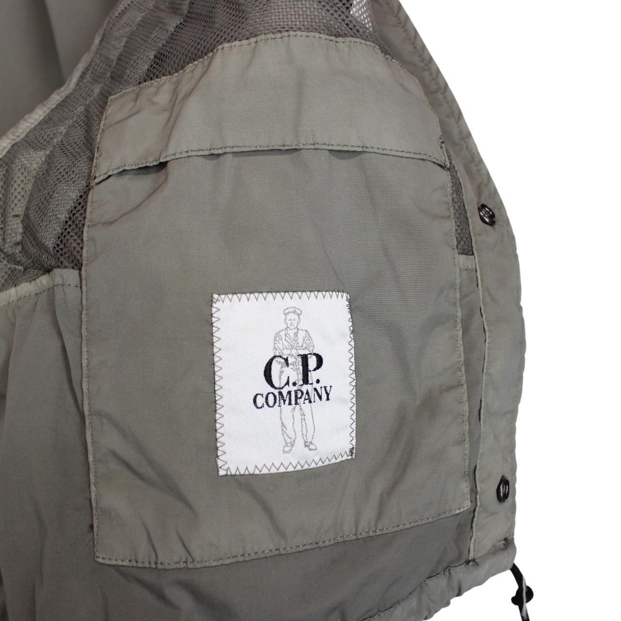 CP Company khaki green and grey jacket with shibori pattern and lens detail.