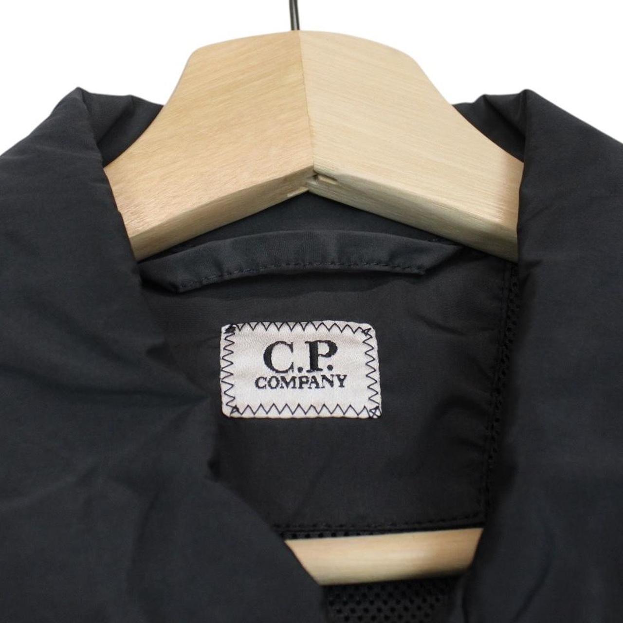 CP Company khaki green and grey jacket with shibori pattern and lens detail.