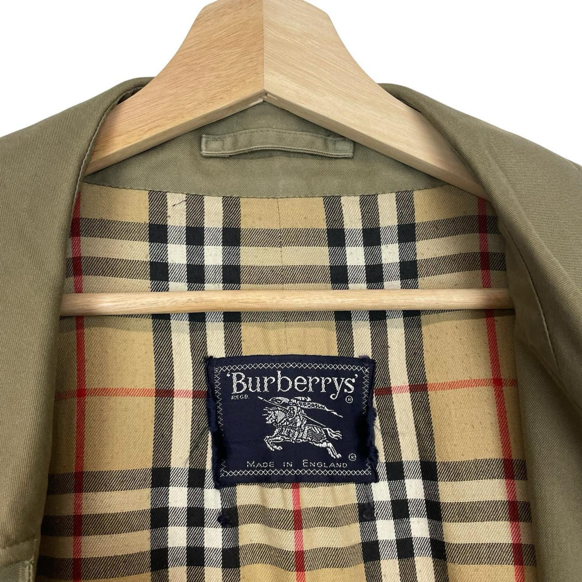 Burberry khaki green trench coat featuring classic Nova Check pattern and single breasted design.