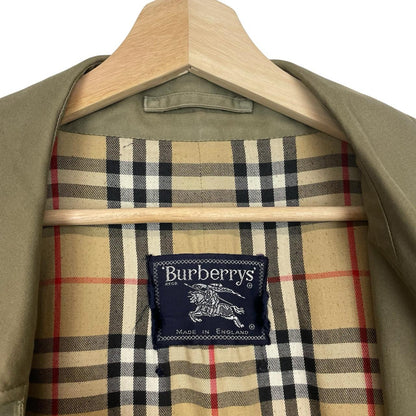 Burberry khaki green trench coat featuring classic Nova Check pattern and single breasted design.