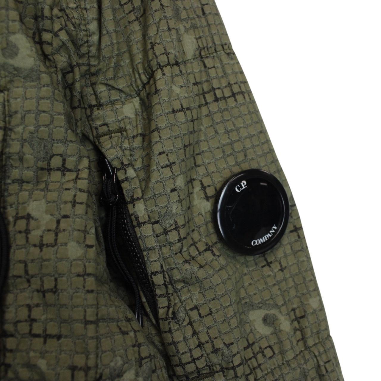 CP Company khaki green overshirt jacket with digital camouflage pattern and lens detail.