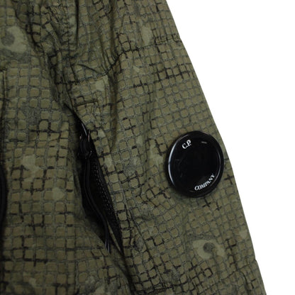 CP Company khaki green overshirt jacket with digital camouflage pattern and lens detail.