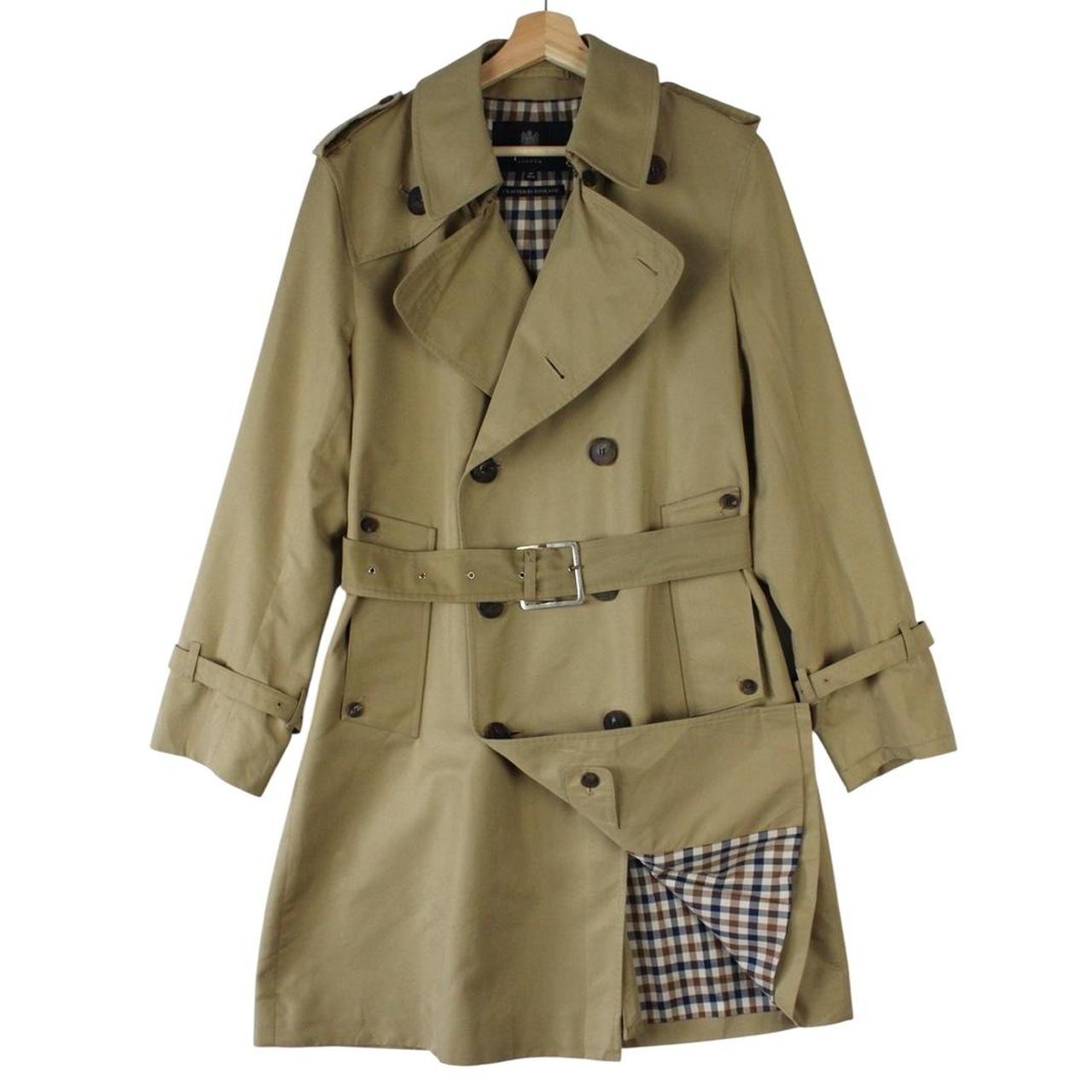 Aquascutum tan brown double breasted trench coat with house check pattern and belted waist.