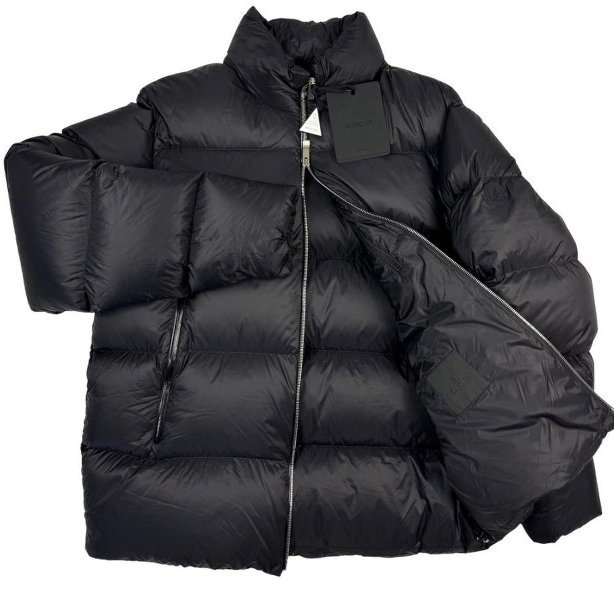 Moncler black nylon down puffer jacket with logo patch and quilted design.