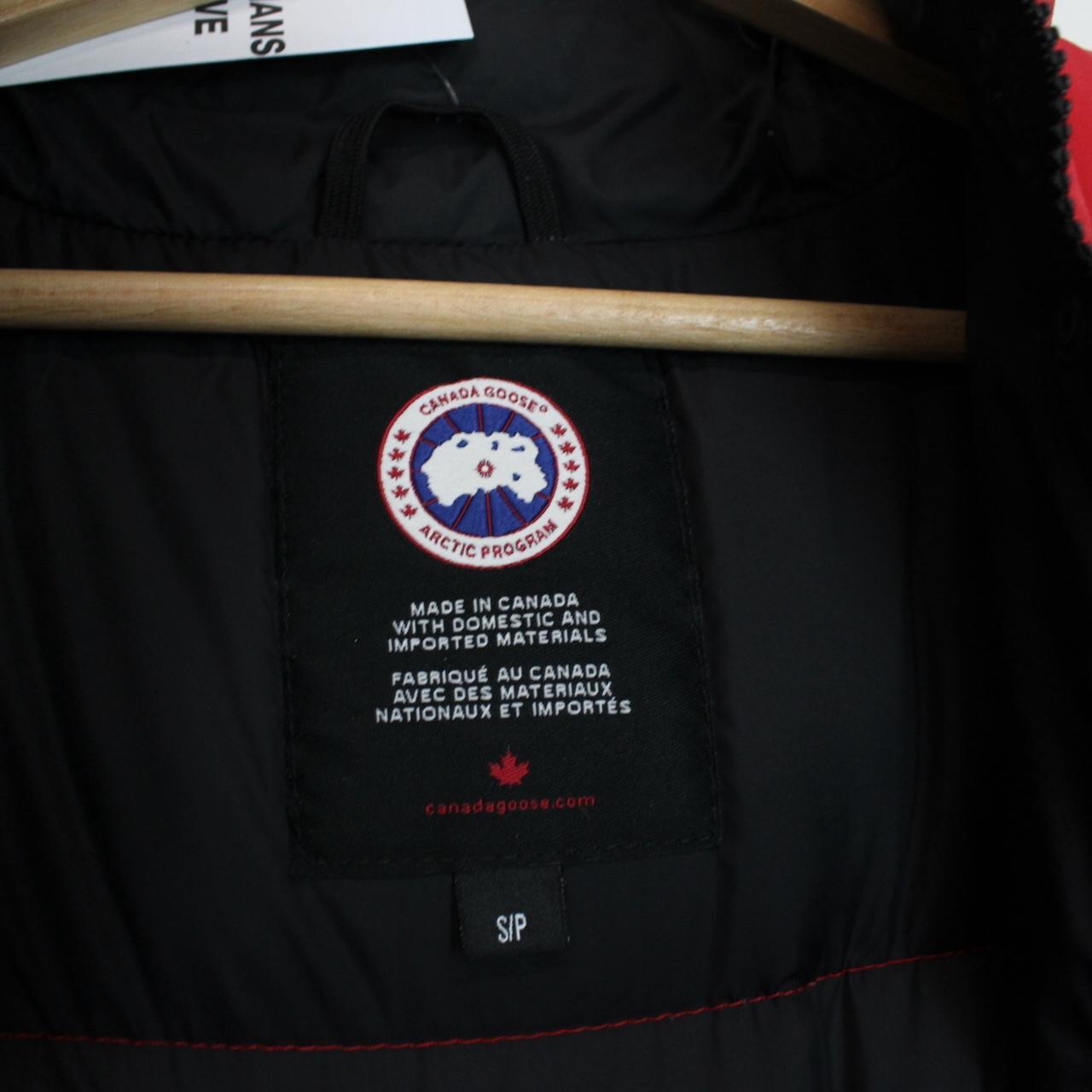 Canada Goose red down gilet with logo patch and zippered pockets.