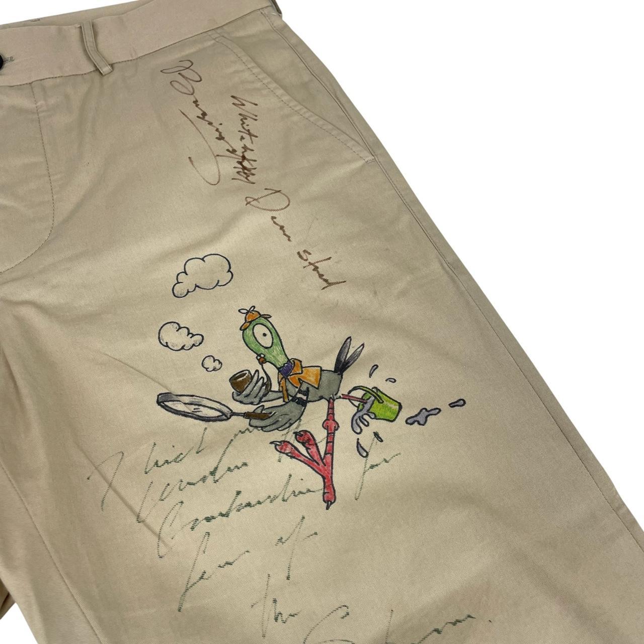 Burberry beige tapered fit trousers with sketch print design and cotton material.