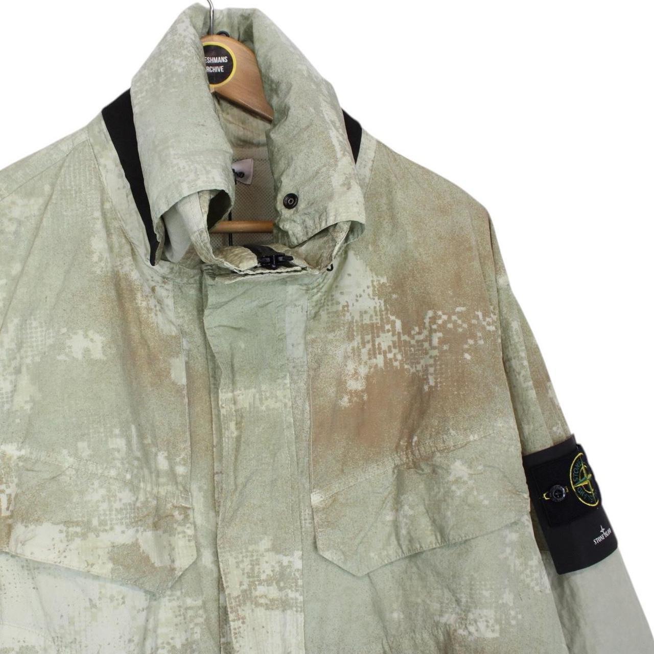 Stone Island green full zip jacket with dissolving grid camo pattern and logo patch.