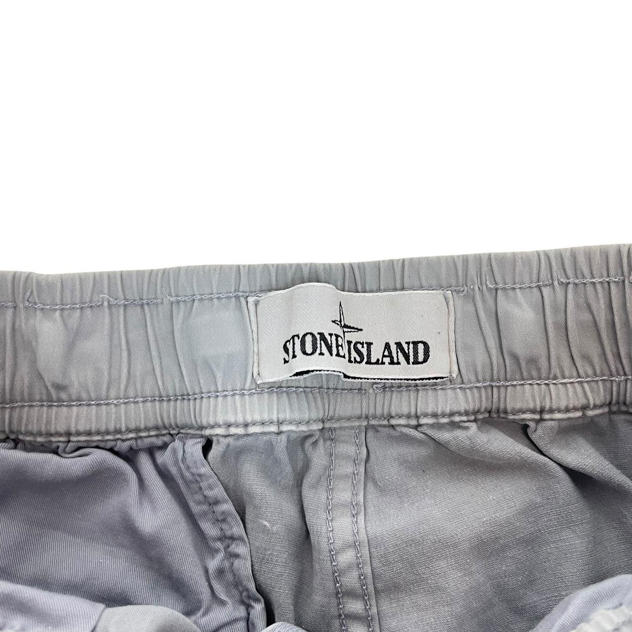 Stone Island blue cargo trousers with logo patch and RE-T fit, visible stain on left leg.