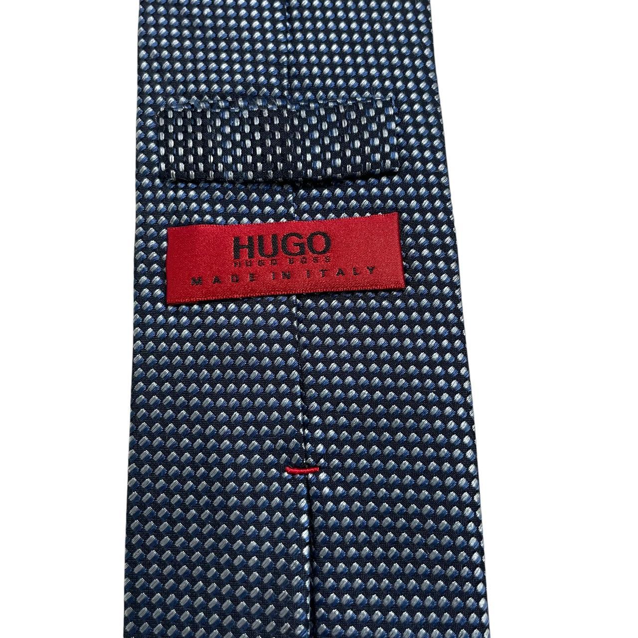 Hugo Boss blue silk tie with white polka dots and logo detail.