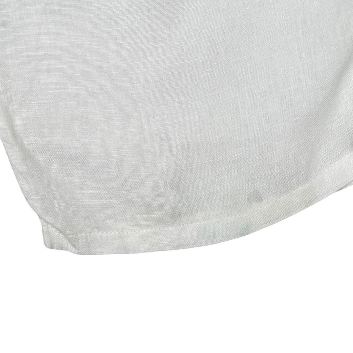 Stone Island white linen Bermuda shorts with logo patch and subtle stains.