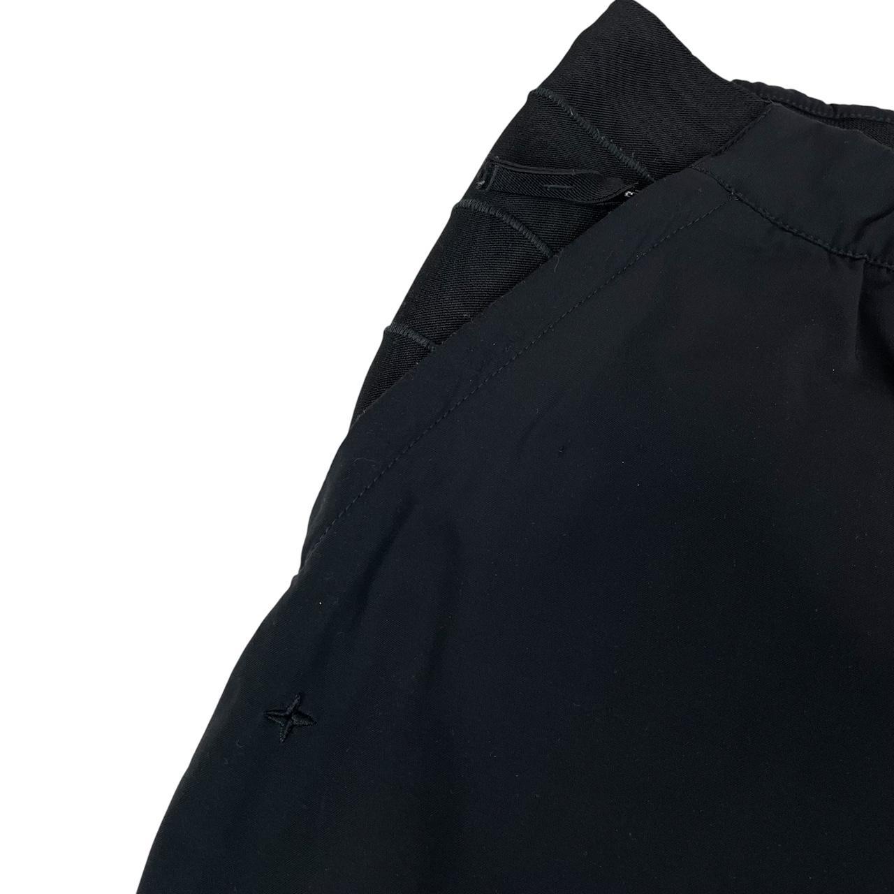 Stone Island navy blue joggers with logo patch and nylon material.