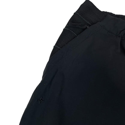 Stone Island navy blue joggers with logo patch and nylon material.
