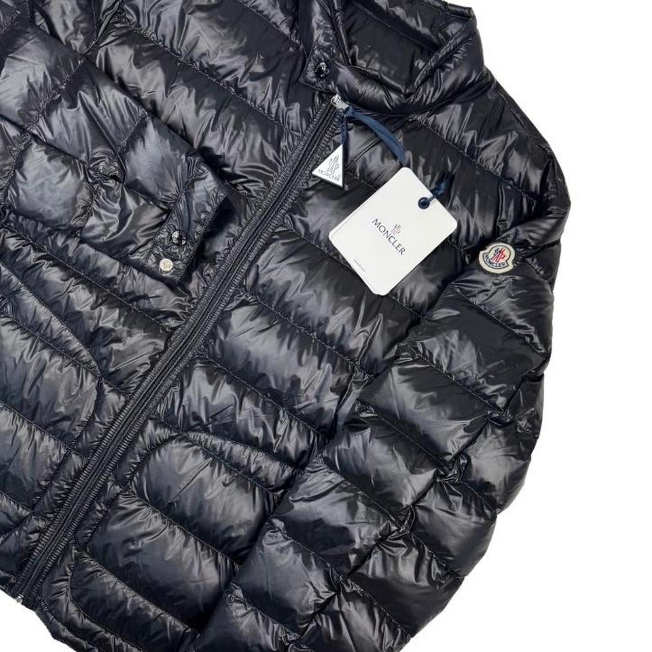 Moncler black nylon down jacket with full zip and logo patch on sleeve.