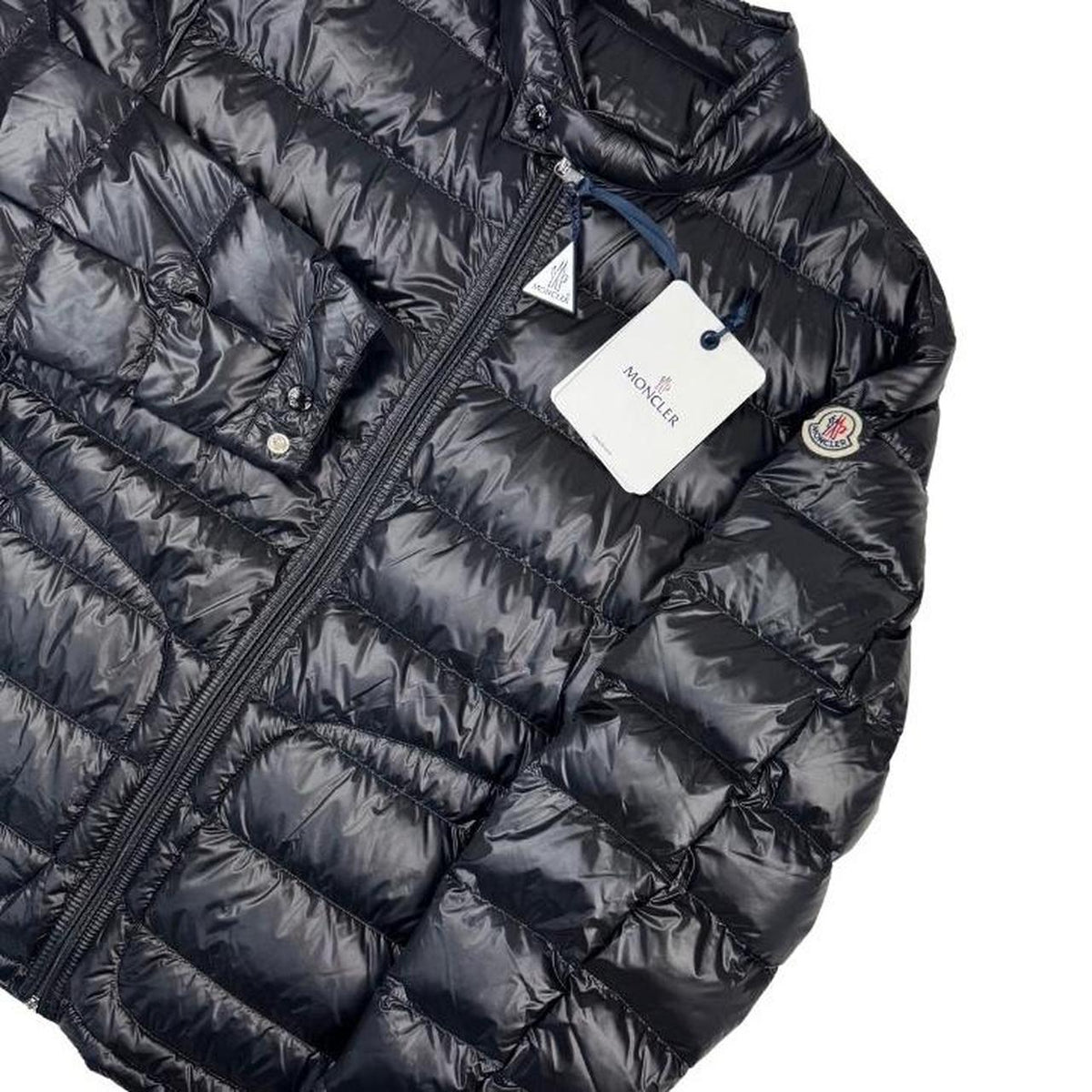 Moncler black nylon down jacket with full zip and logo patch on sleeve.