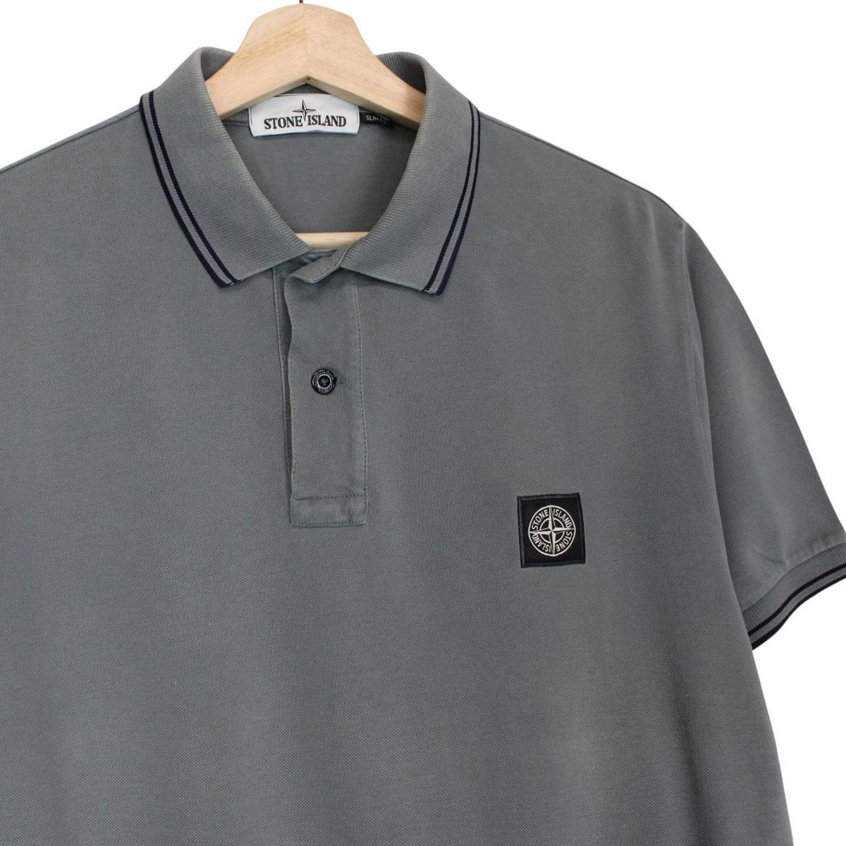 Stone Island grey polo shirt with embroidered compass logo and cotton material.