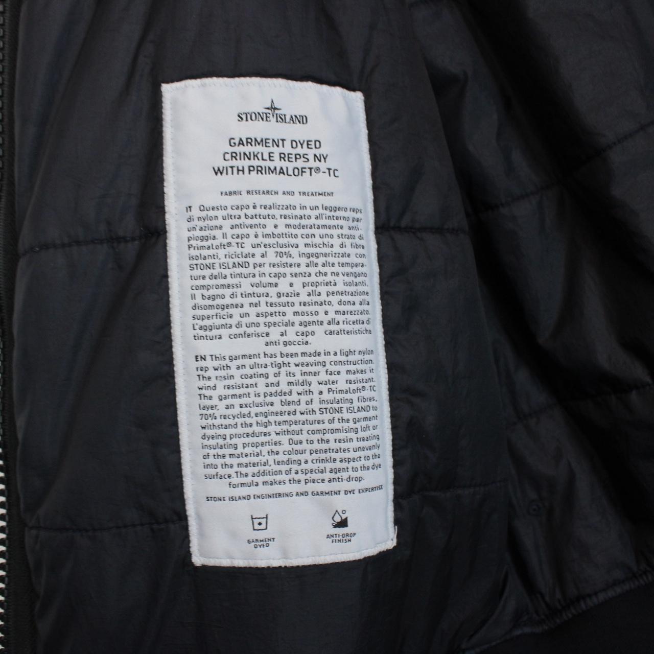 Stone Island black jacket with crinkle texture and logo patch on sleeve.