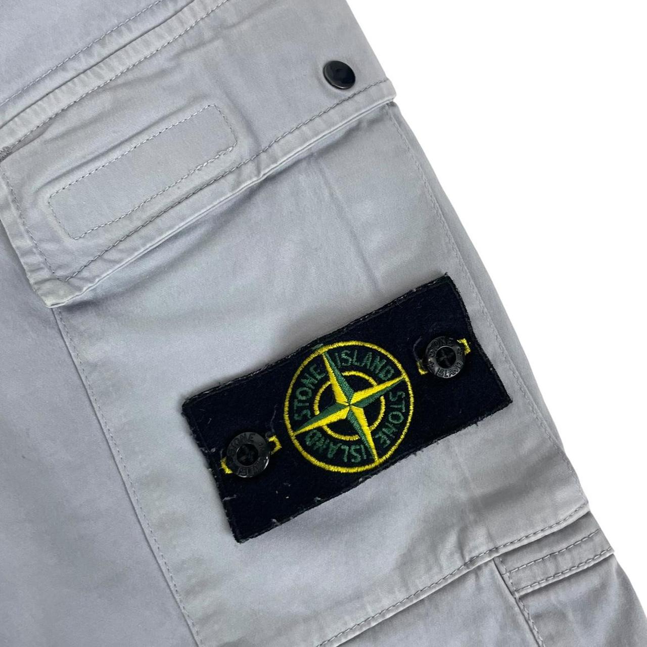 Stone Island blue cargo trousers with logo patch and RE-T fit, visible stain on left leg.