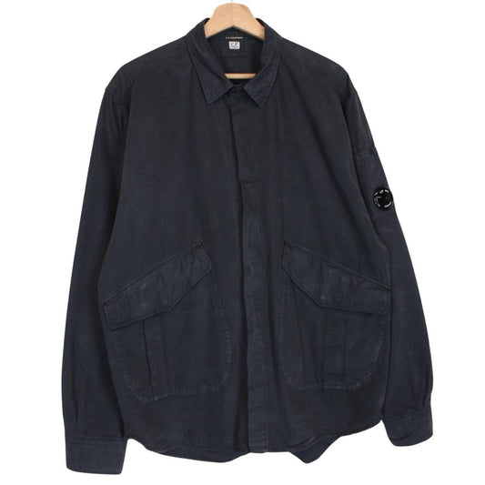 CP Company navy blue overshirt jacket with diamond pattern and lens detail.